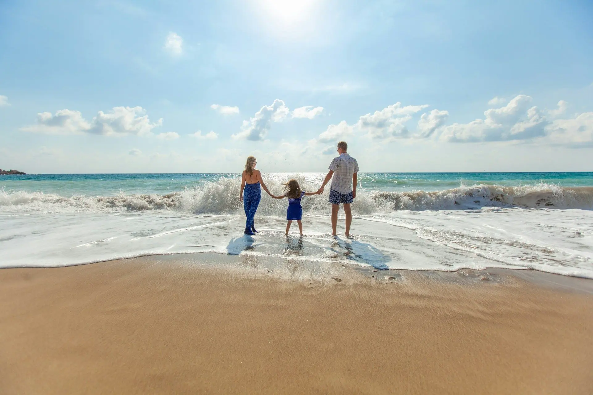 Family on beach with umbrella representing insurance coverage